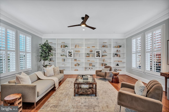 living room featuring ornamental molding, hardwood / wood-style floors, built in features, and ceiling fan