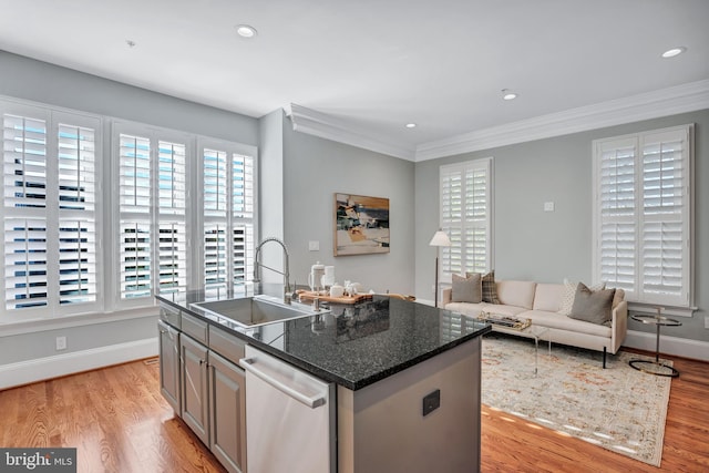 kitchen with sink, dishwasher, a kitchen island with sink, and dark stone countertops