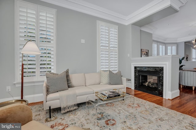 living room with hardwood / wood-style floors, crown molding, and a premium fireplace