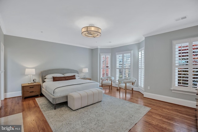 bedroom featuring hardwood / wood-style floors and ornamental molding