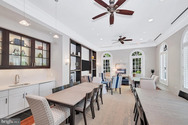 dining area with crown molding, sink, and ceiling fan