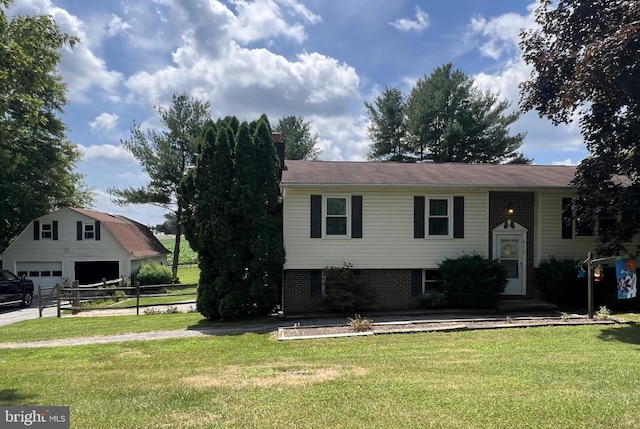 raised ranch with a front lawn, fence, brick siding, and a detached garage