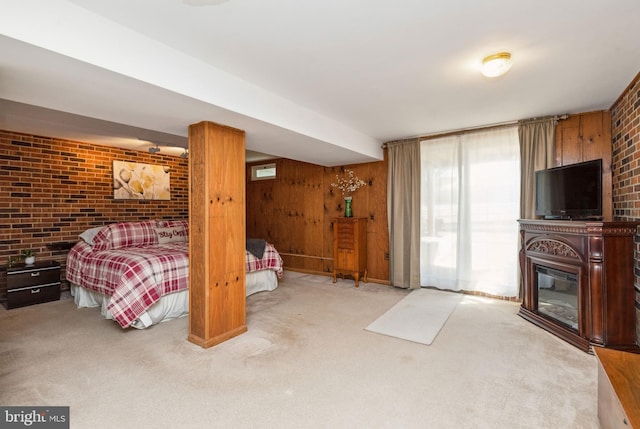 bedroom featuring brick wall, a large fireplace, wood walls, carpet flooring, and access to outside