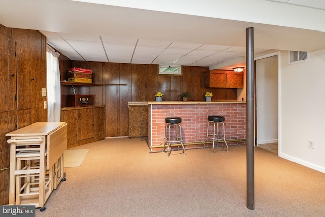 bar featuring visible vents, wood walls, and carpet floors