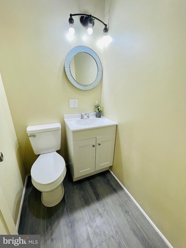 bathroom with vanity, toilet, and hardwood / wood-style floors