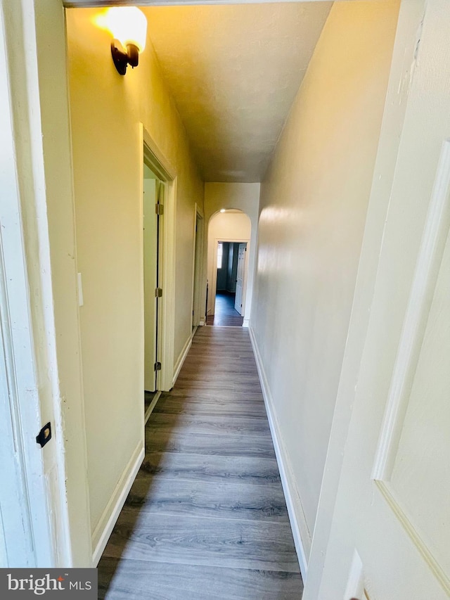 corridor with hardwood / wood-style flooring