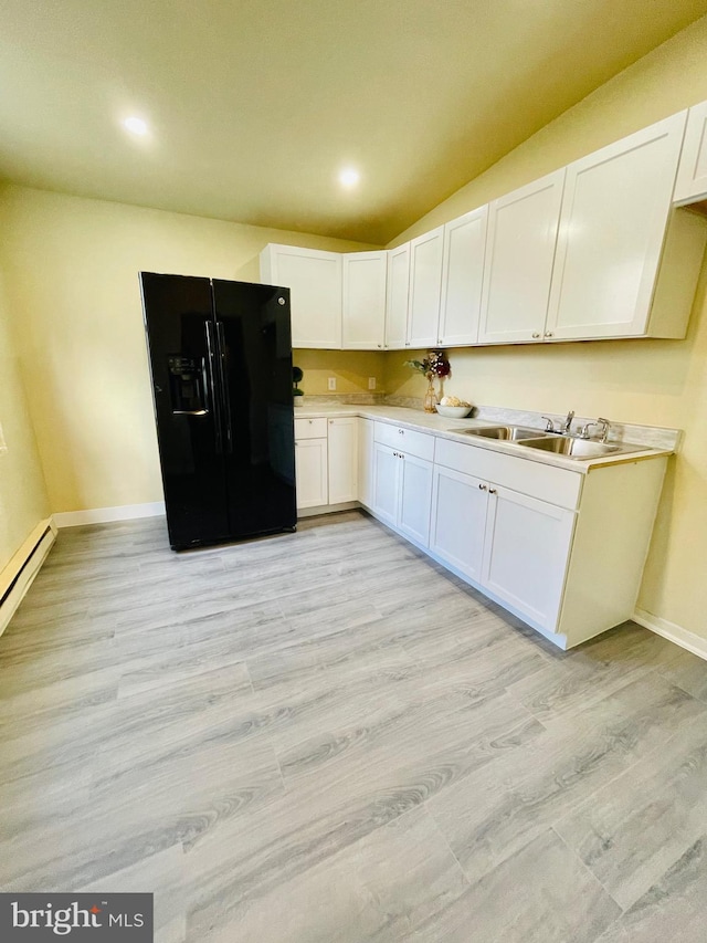 kitchen with sink, white cabinets, black fridge with ice dispenser, and light hardwood / wood-style flooring