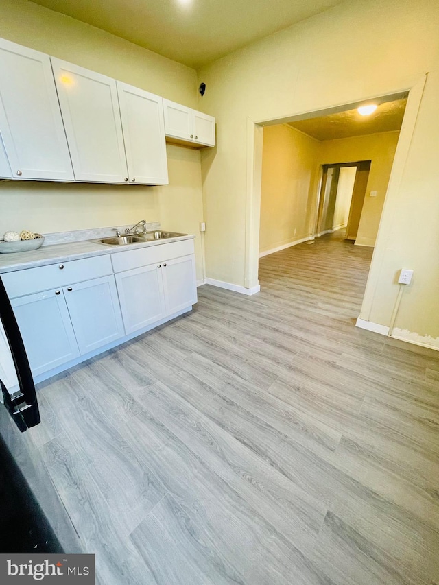 kitchen featuring white cabinetry, sink, and light hardwood / wood-style floors