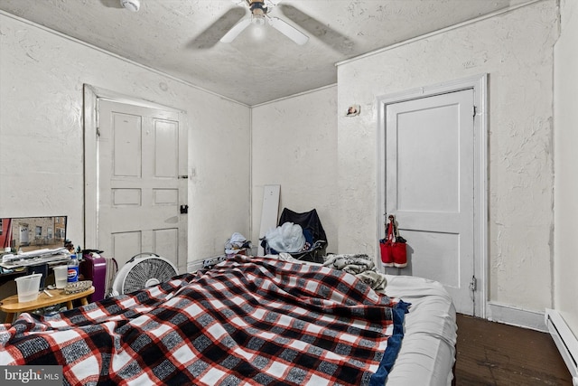 bedroom featuring a baseboard heating unit, ceiling fan, a textured wall, a textured ceiling, and wood finished floors