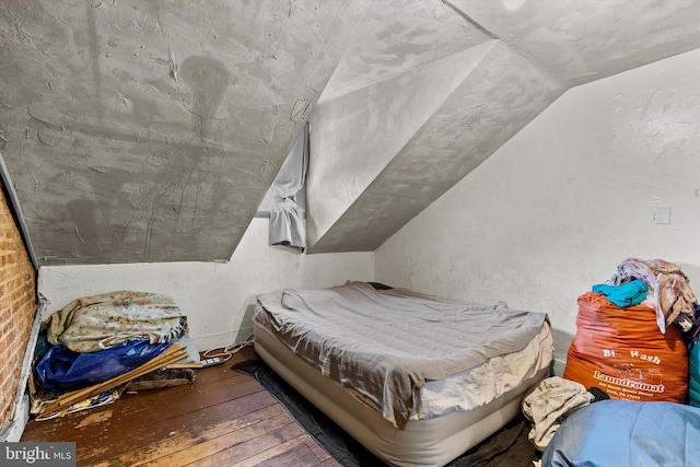 bedroom with lofted ceiling and wood-type flooring