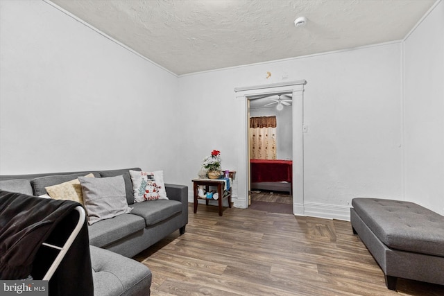 living room with ornamental molding, a textured ceiling, and wood finished floors