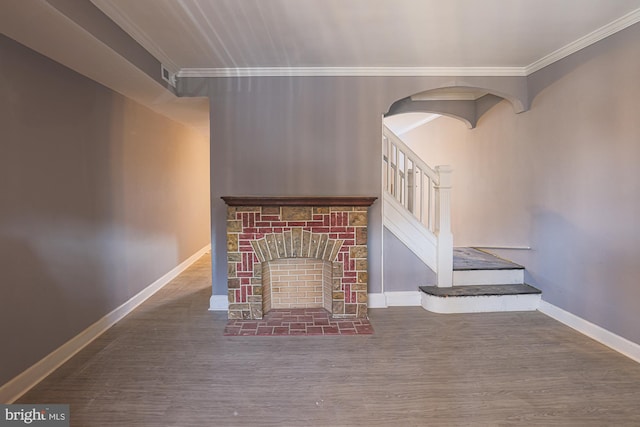 unfurnished living room with crown molding, a brick fireplace, and dark wood-type flooring