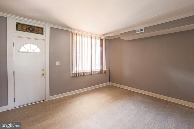 foyer entrance with wood-type flooring and ornamental molding