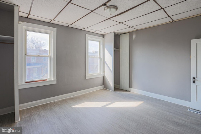 empty room with a paneled ceiling and light wood-type flooring