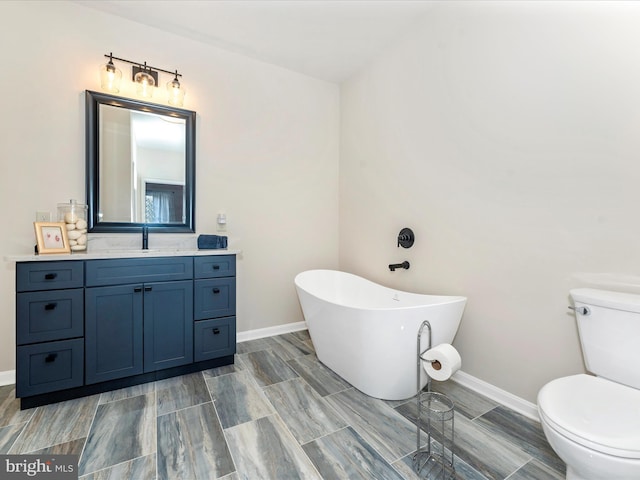 bathroom featuring a tub to relax in, toilet, and vanity