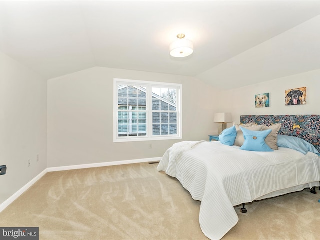 bedroom with lofted ceiling and light colored carpet