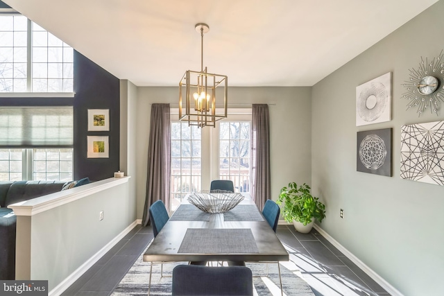 tiled dining room with an inviting chandelier