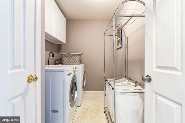 laundry area with independent washer and dryer, light tile patterned floors, and cabinets