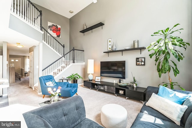 living room featuring carpet floors and a towering ceiling