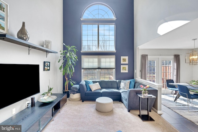 living room featuring an inviting chandelier and a high ceiling