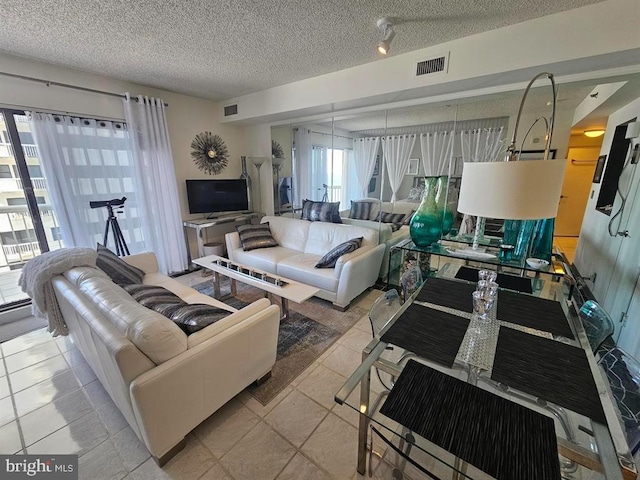 living room with a textured ceiling and light tile patterned floors