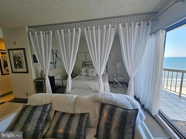 bedroom with a textured ceiling and a water view