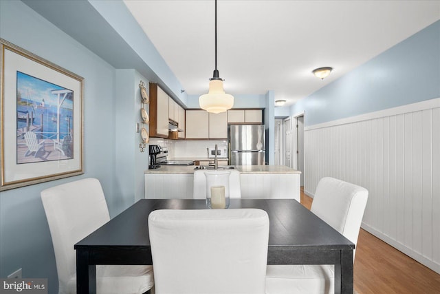 dining space with sink and light hardwood / wood-style flooring