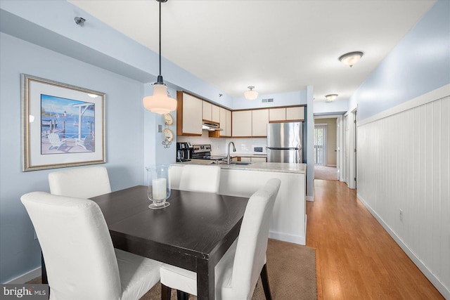 dining area with light wood-style floors and visible vents