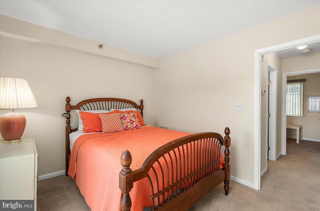 bedroom featuring light carpet and baseboards