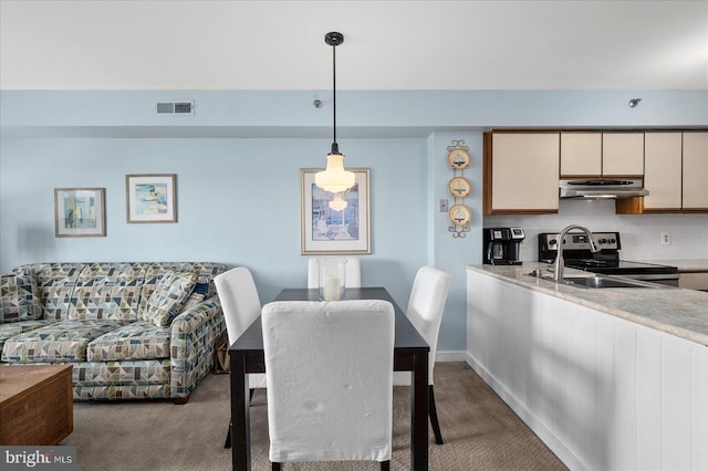 dining room featuring carpet floors, visible vents, and baseboards