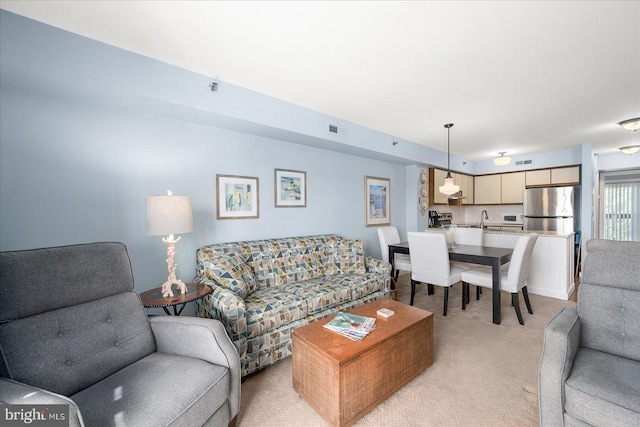 carpeted living room featuring sink