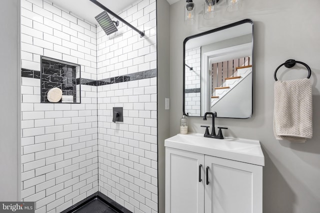 bathroom with vanity and a tile shower