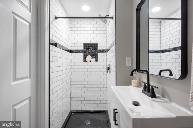 bathroom featuring a tile shower and vanity