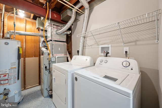 clothes washing area featuring washing machine and clothes dryer and water heater