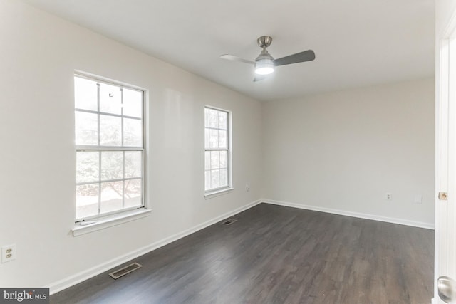 empty room with ceiling fan and dark hardwood / wood-style flooring