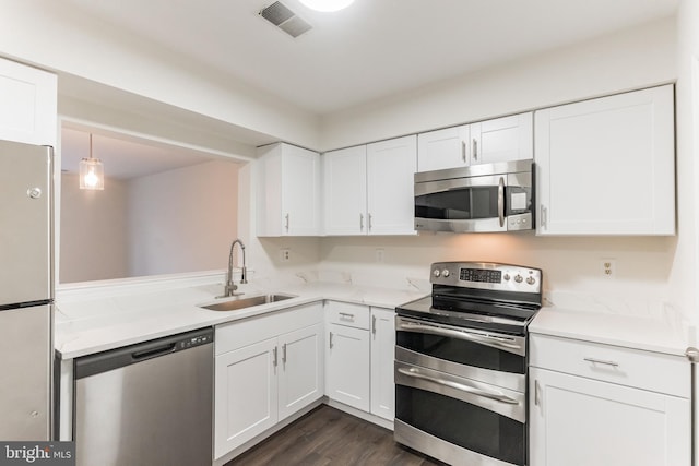 kitchen featuring white cabinetry, appliances with stainless steel finishes, sink, and dark wood-type flooring