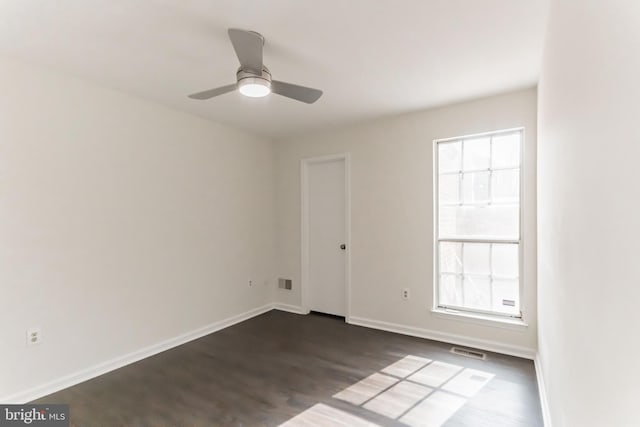 unfurnished room featuring dark wood-type flooring and ceiling fan