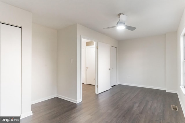 unfurnished bedroom featuring ceiling fan and dark hardwood / wood-style flooring