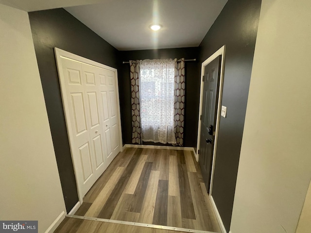 hall featuring baseboards and wood finished floors