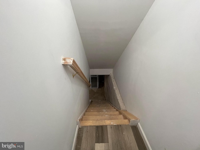 staircase with baseboards and wood finished floors