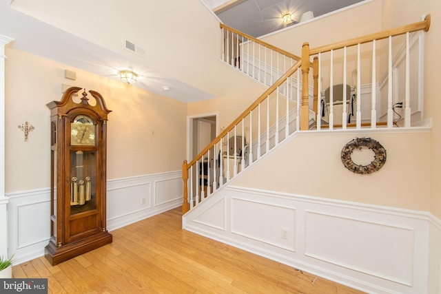 stairs with wood-type flooring and ornate columns