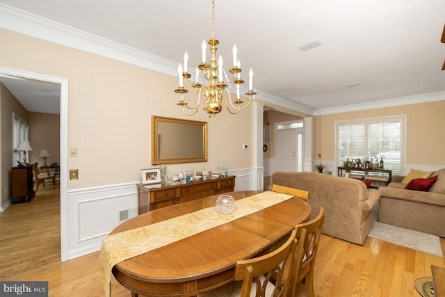 dining space featuring ornamental molding, a chandelier, and light wood-type flooring