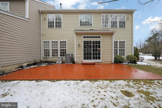 snow covered back of property featuring a deck