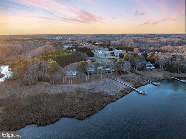 aerial view at dusk featuring a water view