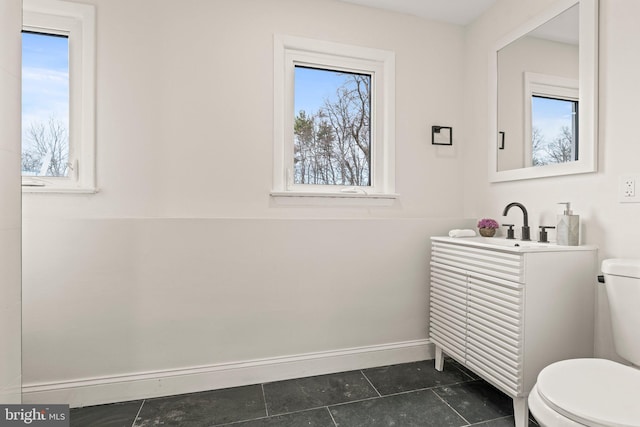 bathroom with vanity, a healthy amount of sunlight, and toilet