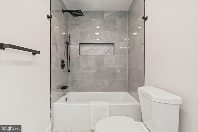 bathroom with tiled shower / bath and toilet