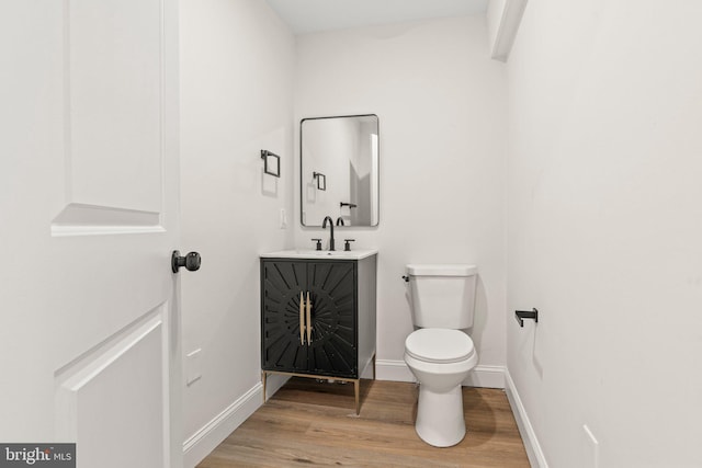 bathroom featuring vanity, hardwood / wood-style flooring, and toilet