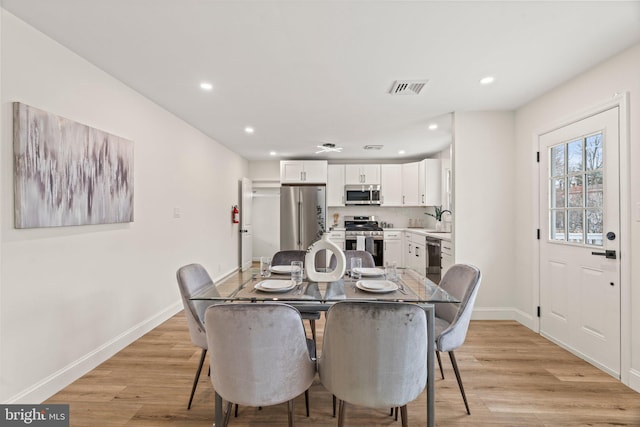 dining area featuring sink and light hardwood / wood-style floors