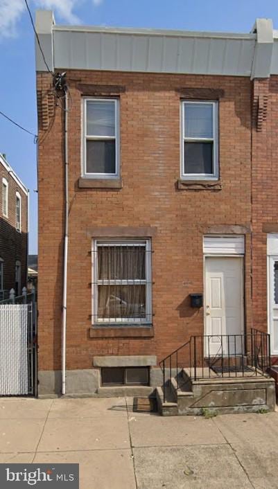 view of front of property featuring brick siding and fence