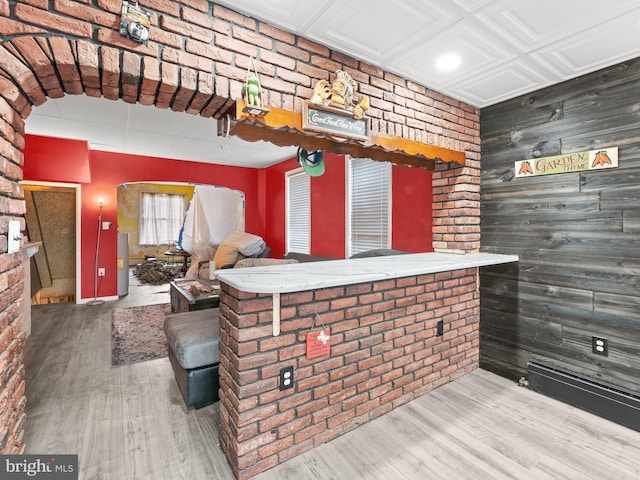 bar with brick wall and wood finished floors